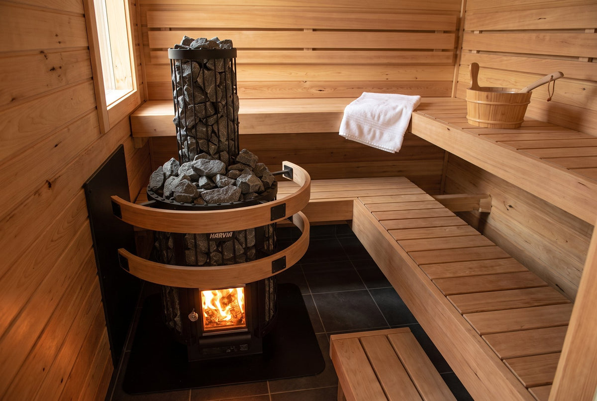 Harvia wood burning sauna stove with fire glowing behind the glass door in a cedar home sauna