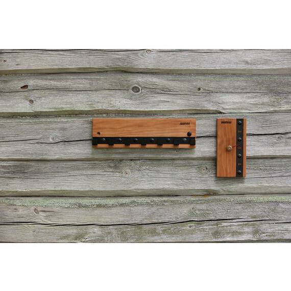 Harvia Legend Clothes Hanger SASPO103 mounted on a weathered wood plank wall next to a sauna control panel