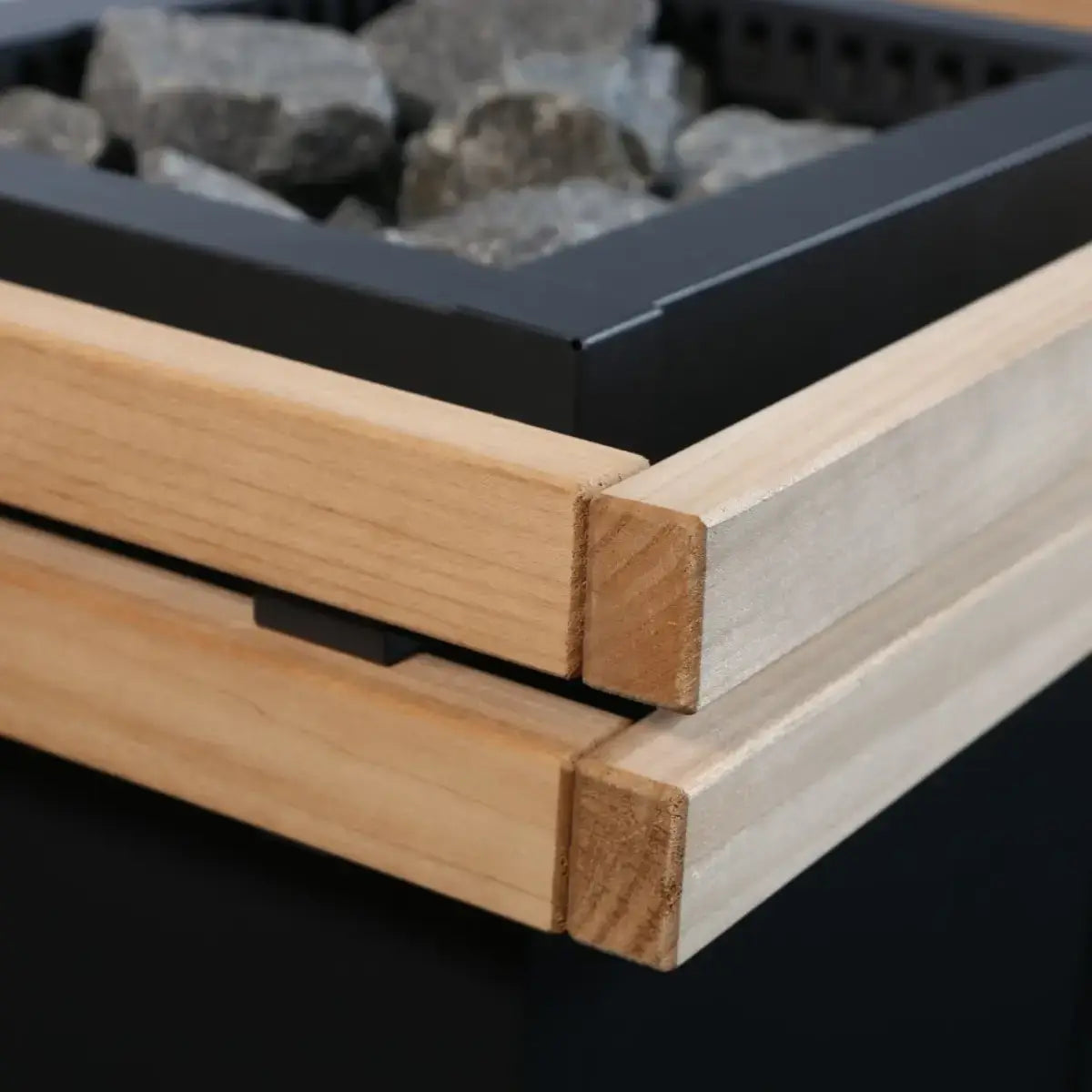 Harvia Virta HL80 8kW Ultimate Electric Sauna Heater Kit, close up of the wood guard rail corner joinery with stones in the heater cage.