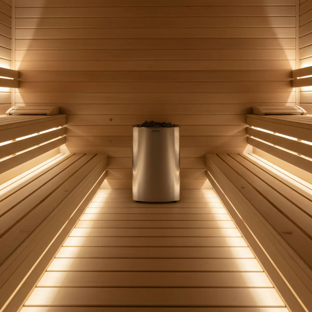 Harvia Club K15G 15kW Electric Sauna Heater installed between two wood benches in a sauna with warm LED strip lighting.