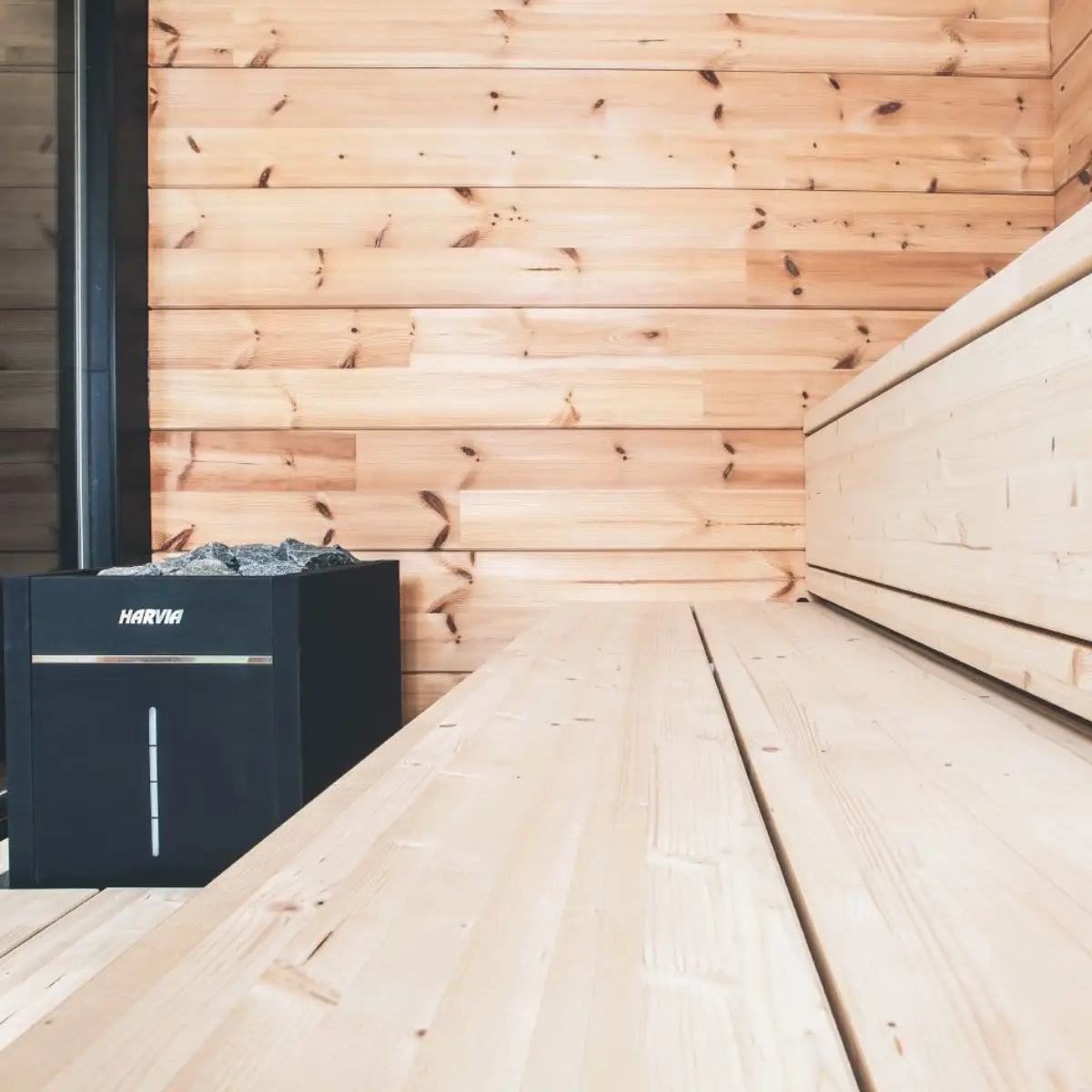Harvia Virta Combi HL80SA 8kW Electric Sauna Heater and Steamer, installed in a cedar sauna corner beside a light wood bench, low close view
