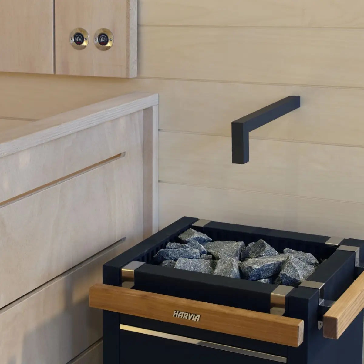 Harvia Virta HL60 6kW Electric Sauna Heater, close up of the stone tray and wall mounted timer dials in a sauna interior.