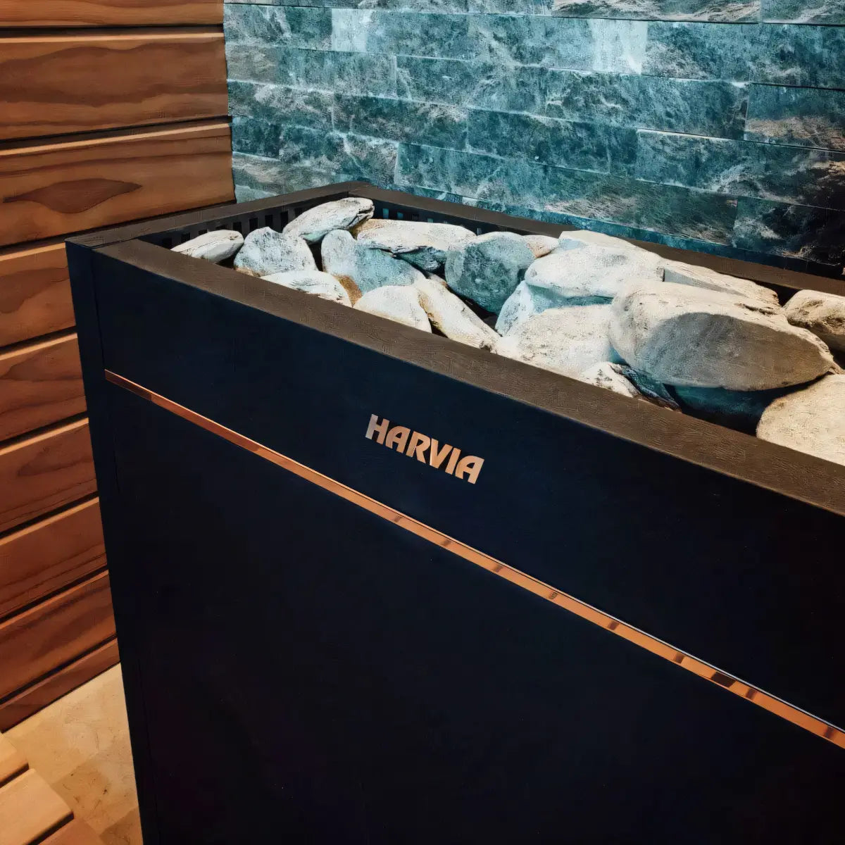 Harvia Virta Pro HL200 20kW Electric Sauna Heater, close up of the stone tray and logo plate against a stacked stone wall.
