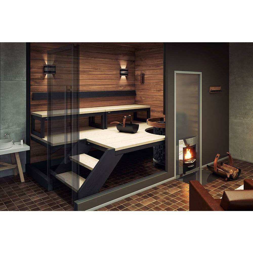 Harvia Legend Bucket SASPO100 Sauna Bucket set on the sauna bench near the heater, with wood paneled walls and a glass door.