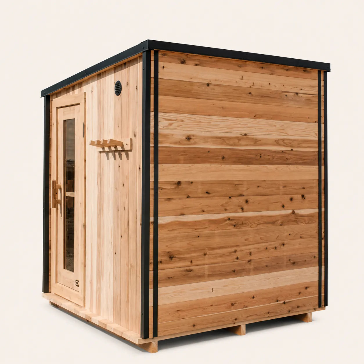 The Summit cedar 4-6 person outdoor sauna front-angled view on white background showing slanted roof, glass door with SK logo, side window, and exterior cedar peg rack.