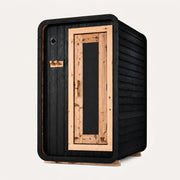 The Sweat Pod Black Edition Shou Sugi Ban charred cedar sauna on white background, three-quarter angle with natural cedar door frame.