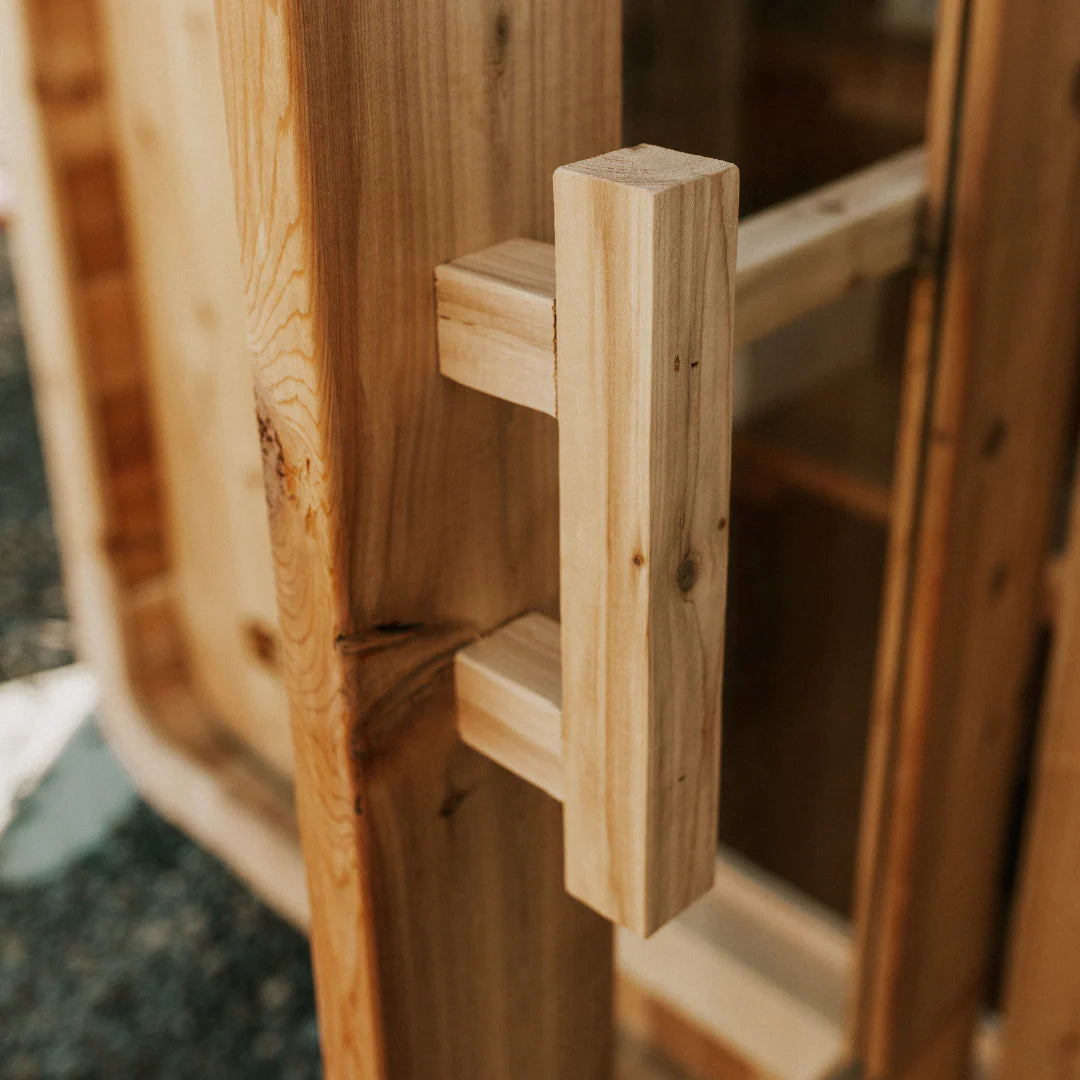 Close-up detail of the handcrafted cedar door handle on The Sweat Pod sauna.