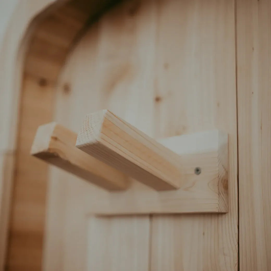 Close-up of cedar towel and robe hook detail on the exterior of The Sweat Pod sauna.