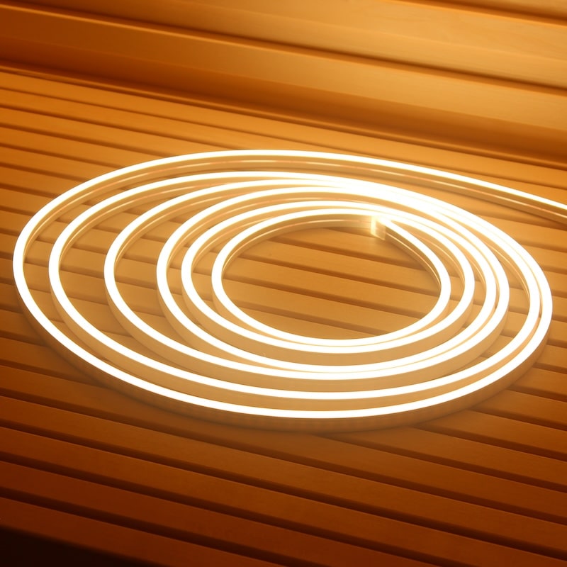 PROSAUNAS 16-ft dotless LED sauna light strip glowing warm white on a wood bench