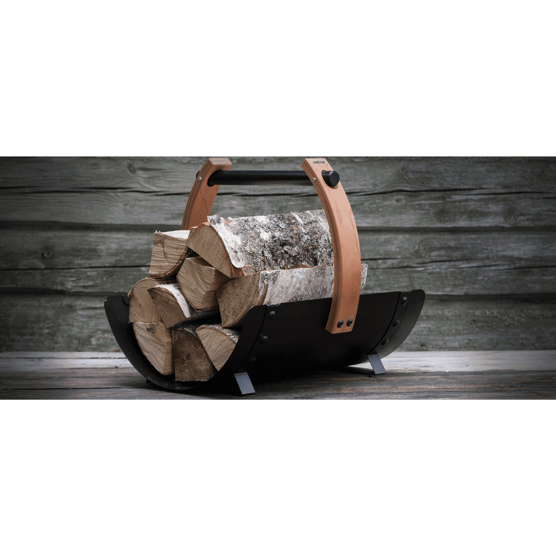 Harvia Legend Firewood Basket SASPO102 loaded with stacked birch logs against a weathered wood plank backdrop, close side view
