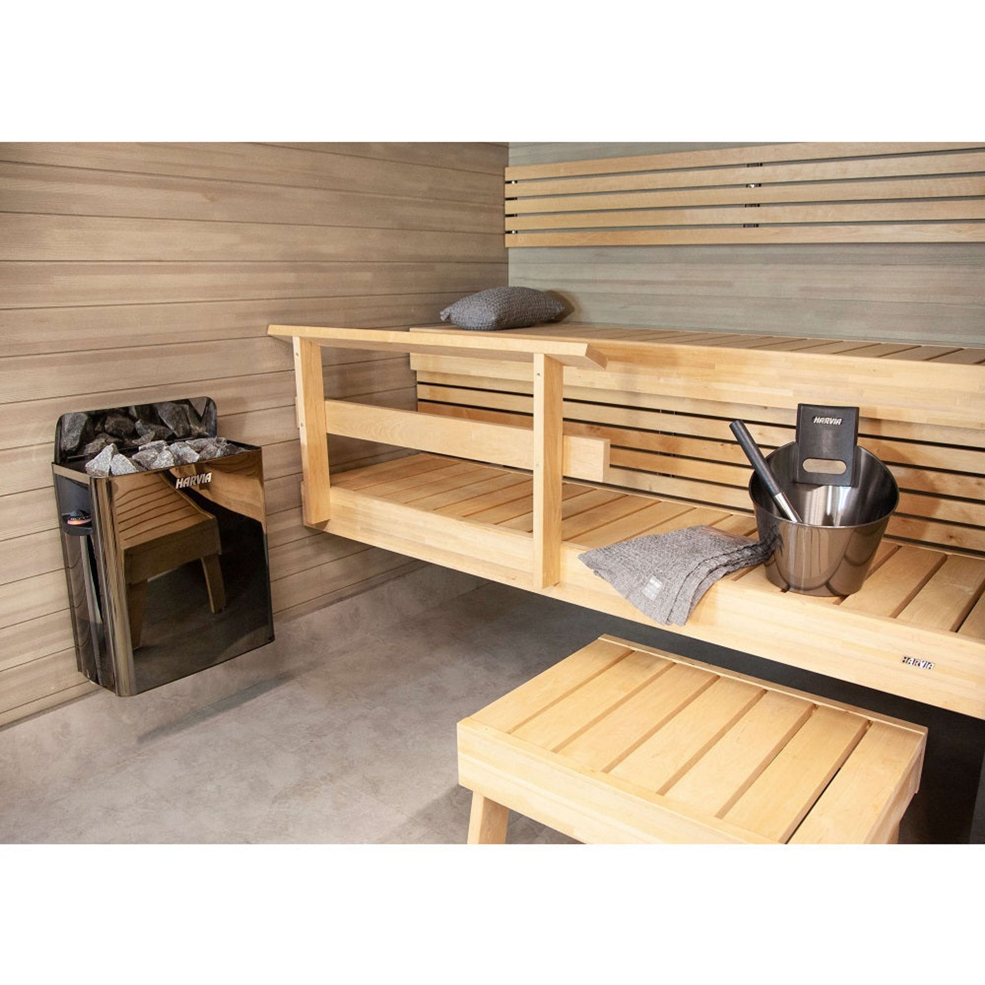 Harvia SA007 Black Sauna Accessories Set, displayed in a sauna interior with bucket and ladle on a bench beside the heater.