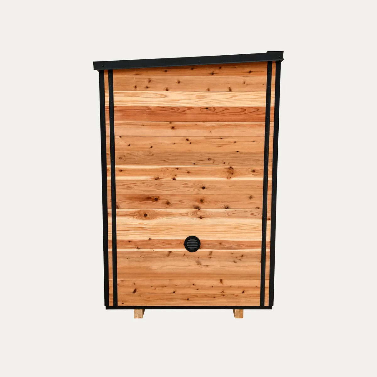 Opposite side of the Sweat Kingdom Ridge sauna showing wood siding, black trim, and a lower wall vent.