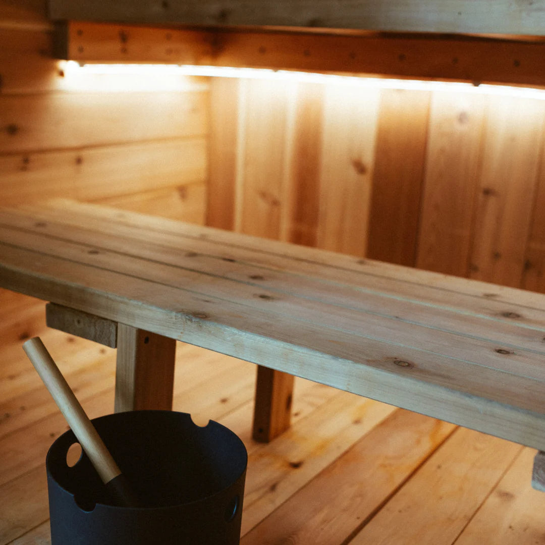 Warm white LED strip lighting installed under a sauna bench to highlight the wood interior